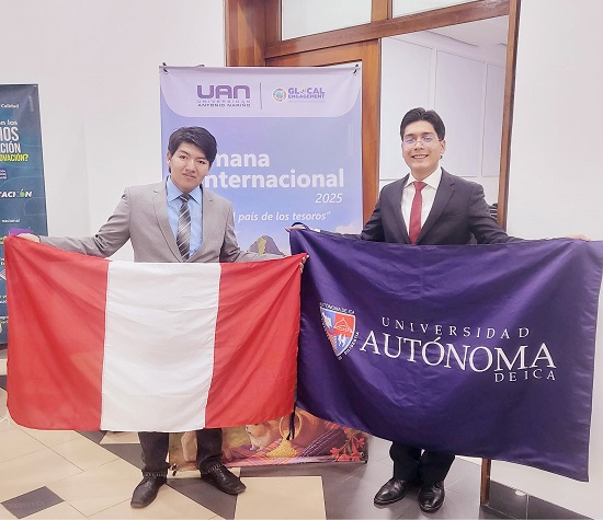 Dos jovenes posan frente a un afiche de la Semana Internacional 2025 Cada uno sostiene una bandera uno la de Peru y el otro la de su universidad, mientras sonrien a la camara