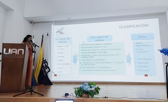 Una persona esta dando una presentacion en un auditorio de la UAN mostrando en una pantalla una diapositiva sobre la clasificacion de enfermedades tropicales